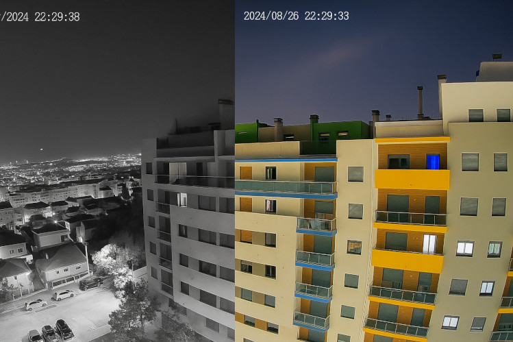 Edifício residencial à noite com varandas e janelas iluminadas, imagem parcialmente a cores e preto e branco, com data e hora visíveis