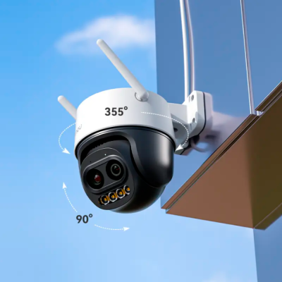 Câmara de vigilância exterior com antenas e lentes duplas numa estrutura branca, contra céu azul.