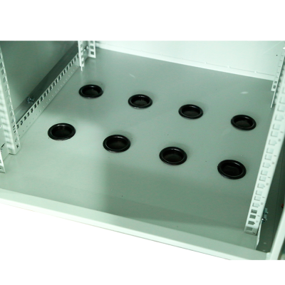 Interior de móvel metálico cinzento com passagens redondas pretas no fundo.