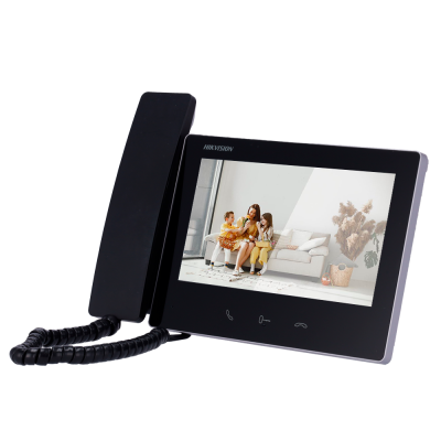 Telefone de videoconferência preto com ecrã a mostrar imagem de família num sofá branco.