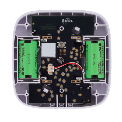 Interior de dispositivo eletrônico com duas baterias verdes e placa preta