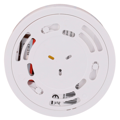 Sensor de fumo branco redondo com ventilação e etiqueta visível