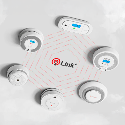 Dispositivos brancos de deteção de fumo ou gás com ecrãs digitais, ligados entre si em círculo com o texto Link+