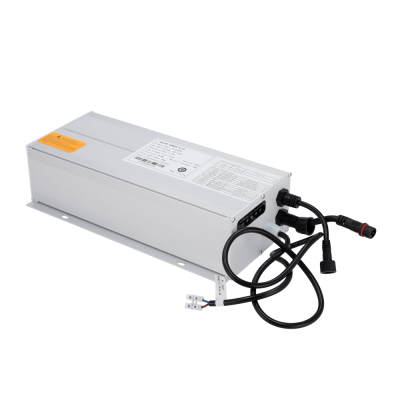 Transformador elétrico metálico prateado com cabos pretos e etiquetas branca e amarela