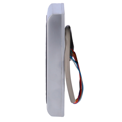 Aparelho eletrónico metálico com fios coloridos ligado a suporte branco com tecido cinza