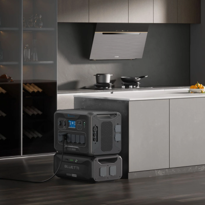 Gerador portátil preto BLUETTI numa cozinha moderna com armários cinza e fogão