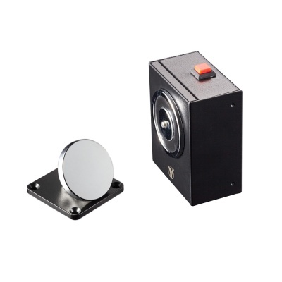 Dispositivo retangular preto com botão vermelho e base metálica com disco prateado