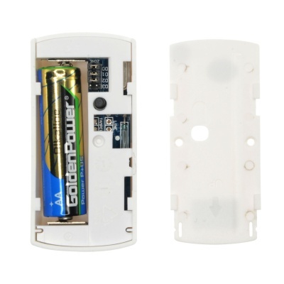 Dispositivo eletrónico branco aberto com pilha AA Goldent Power e tampa ao lado.