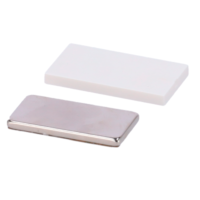 Dois objetos retangulares, um branco e outro metálico prateado sobre fundo branco