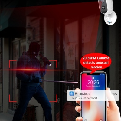 Câmera de segurança branca em parede detectando movimento suspeito, com notificações num telemóvel