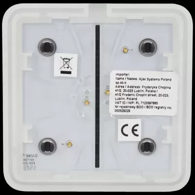 Placa branca quadrada com etiquetas e pontos de fixação metálicos.