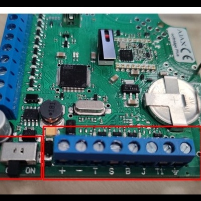 Placa eletrónica verde com conectores azuis e componentes diversos