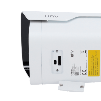 Câmara IP branca UNV com etiqueta amarela de instruções e fundo branco.