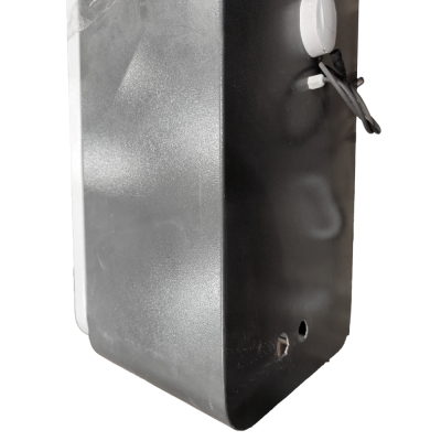 Caixa metálica preta com textura e dois furos na base sobre madeira clara