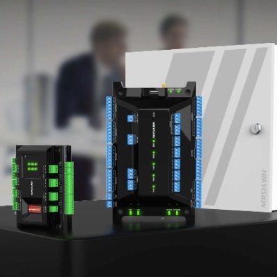 Equipamentos eletrónicos Hikvision com várias ligações coloridas e caixa branca fechada sobre mesa preta