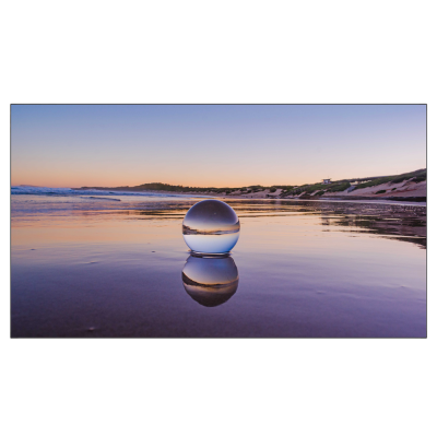 Esfera de vidro na praia ao pôr do sol