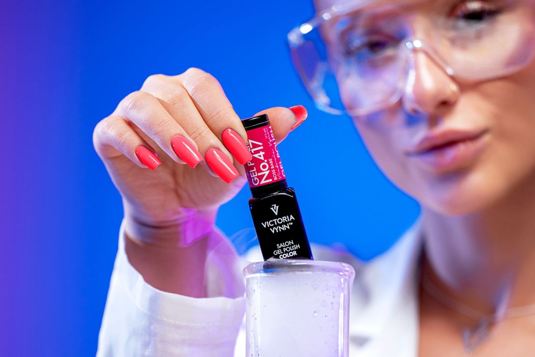 Frasco de verniz gel Victoria Vynn e mão com unhas pintadas cor rosa