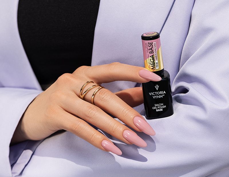 Mãos femininas com unhas rosas segurando dois frascos de esmalte