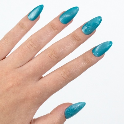 Unhas compridas azuis com detalhes de estrela branca numa mão sobre fundo branco.