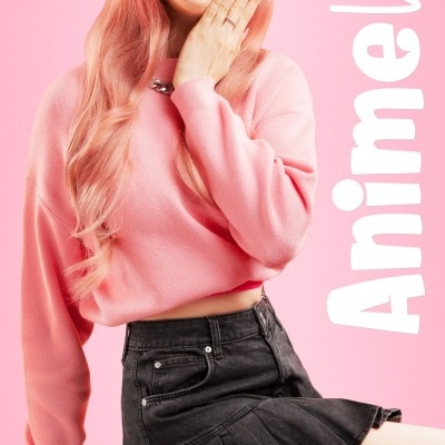 Mulher com suéter rosa e saia preta com texto AnimeVibe ao fundo