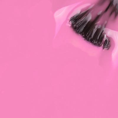 Pincéis aplicadores pretos em líquido rosa brilhante