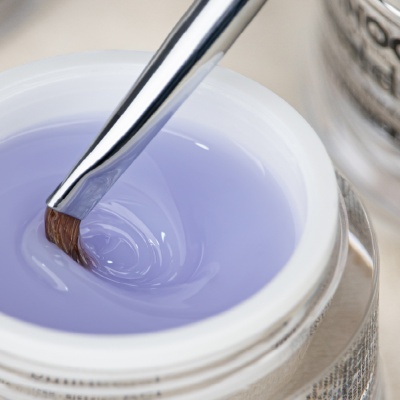 Frasco aberto com gel lilás claro e pincel de manicure metalizado dentro