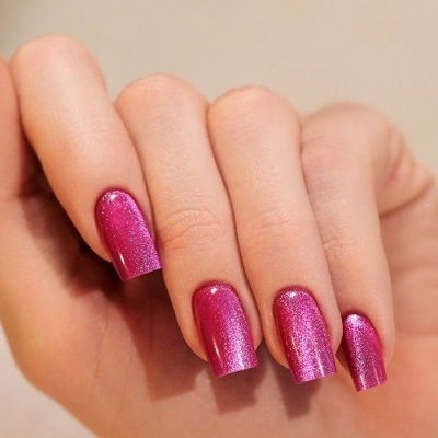 Mão com unhas quadradas pintadas de verniz rosa cintilante