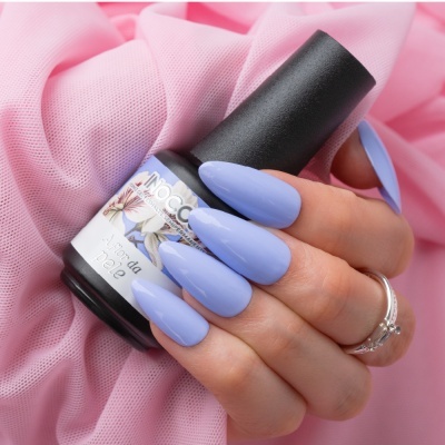 Frasco de verniz MOCCA com unhas azuis e fundo cor de rosa