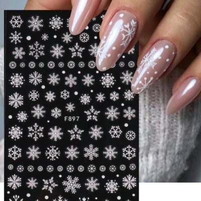 Unhas decoradas com flocos de neve e autocolantes de unhas com padrões de flocos de neve.