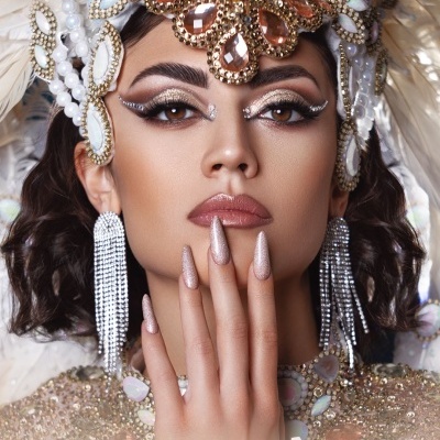 Modelo com verniz dourado metálico e adorno de cabeça detalhado