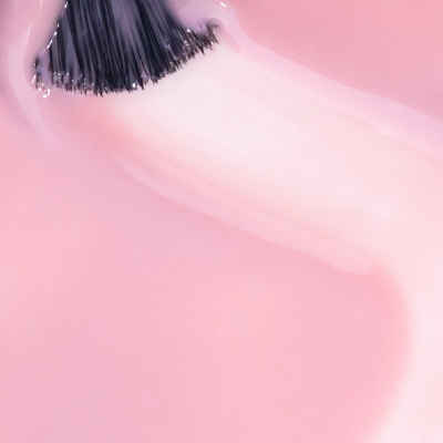 Pincel de unha com esmalte rosa claro