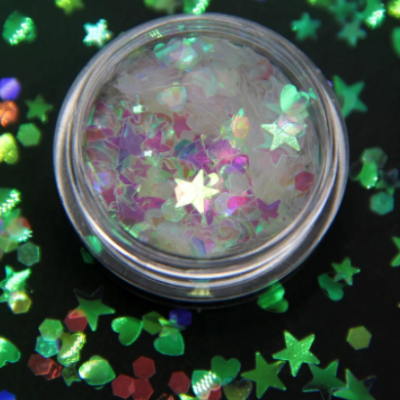 Pote transparente com glitter colorido em formas variadas sobre fundo escuro