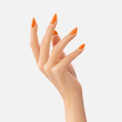 Mão feminina com unhas laranja brilhantes e alongadas em fundo cinzento claro