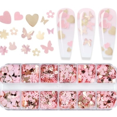 Pequenas peças decorativas para unhas em rosa, dourado e bege, em caixa transparente.