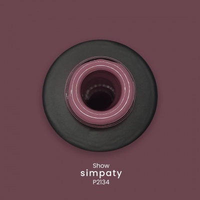 Anel circular preto com interior rosa e centro oco sobre fundo castanho-escuro