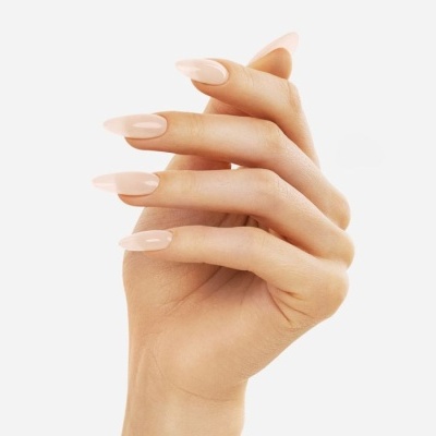 Mão feminina com unhas nude brilhantes