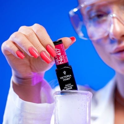 Frasco de verniz gel Victoria Vynn e mão com unhas pintadas cor rosa