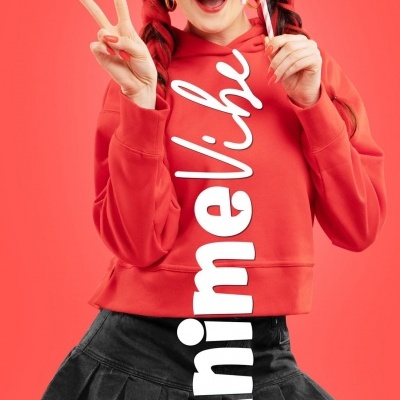 Mulher jovem a vestir sweatshirt vermelha com texto branco e saia preta, segurando bengala doce