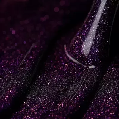 Pincel de maquilhagem com glitter roxo em fundo correspondente