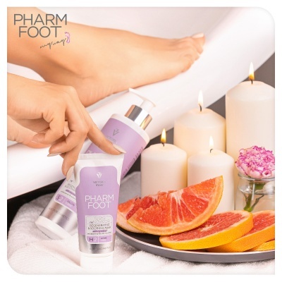 Produtos PHARM FOOT lilás para cuidados dos pés junto a velas, toranja e flor rosa.