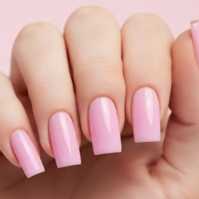 Unhas longas quadradas com verniz rosa claro brilhante em fundo rosa