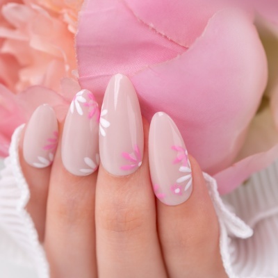 Unhas decoradas com flores rosa e branco, mão feminina segurando flor rosa