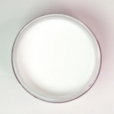 Frasco redondo transparente com creme branco visto de cima