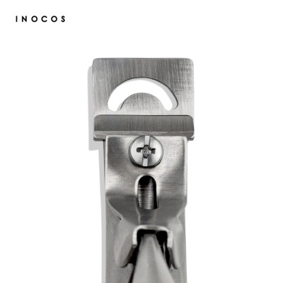 Alicate metálico prateado visto de cima com texto INOCOS no fundo branco