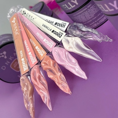 Amostras de verniz gel DNKA em várias cores sobre fundo lilás com recipientes roxos