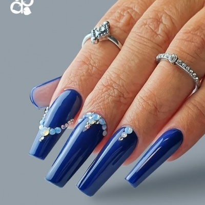 Unha postiça azul escuro com cristais e argolas