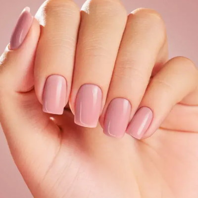Mão com unhas em gel rosa claro brilhantes