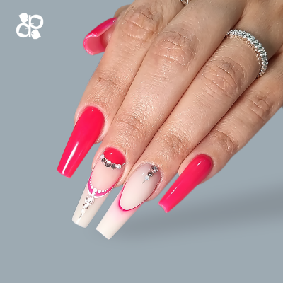 Mãos femininas com unhas decoradas em rosa e nude com cristais e anel prateado