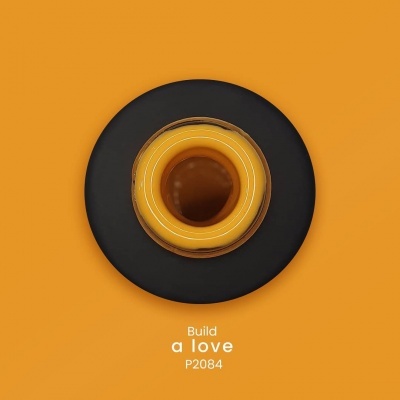Donut com cobertura amarela sobre prato preto com texto 'Build a love P2084'