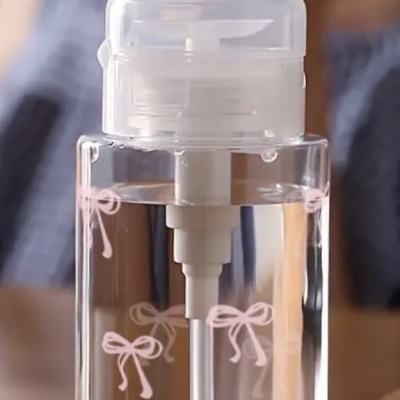 Frasco transparente com tampa branca e laços cor-de-rosa